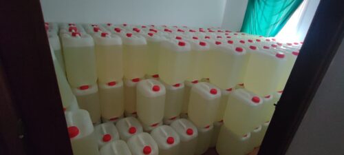 Habitación repleta de garrafas apiladas con líquido amarillento y tapón rojo, almacenadas como combustible para abastecer a narcolanchas dedicadas al narcotráfico.